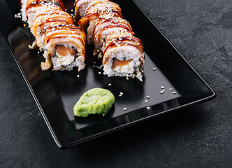 Sushi eel roll maki on black plate