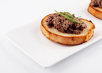 delicious italian bruschetta with truffle pate on white plate