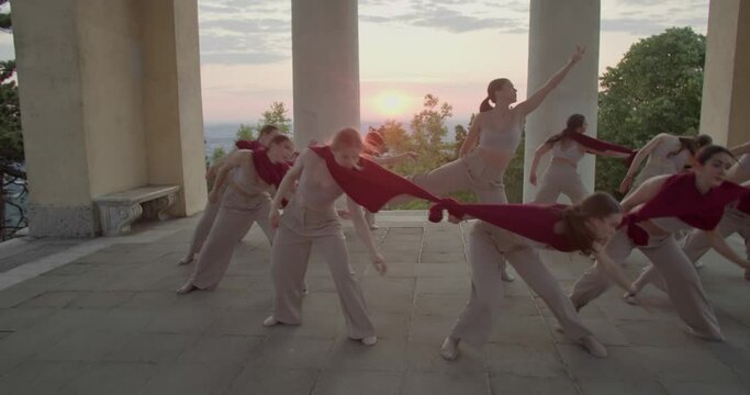Sunrise in the background of young people interpretive dancing in a temple, 4k