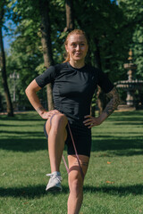 Obraz premium young sportswoman girl doing physical exercises on a sports mat training with rubber bands on her legs outside in the park healthy lifestyle concept