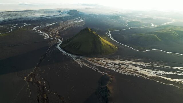 Aerial view of Maelifell mountain at sunset, a tall volcano that stands out in a desert of black sands, Iceland.