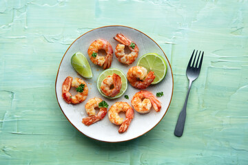 Shrimps, overhead shot. Fried shrimp with parsley and lime, shot from the top on a teal table, with a fork
