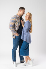Man and woman hugging while looking at the camera. A young married couple.