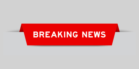Red color inserted label with word breaking news on gray background