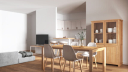 Blurred background, modern scandinavian dining and living room. Wooden table with chairs, island with stools. Partition wall over kitchen. Minimal interior design
