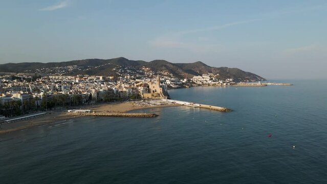 Aerial view of Sitges cathedral along the Mediterranean Sea coastline at sunset, Barcelona, Spain.