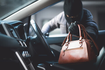 Thieves are stealing wallets in the car. - obrazy, fototapety, plakaty