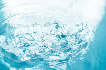 Naklejka na ściany i meble Defocus blurred blue color water ripple surface clear calm texture background with splashing bubbles water drop. Abstract and nature concept. Shiny water wave sunlight reflection shining copy space.