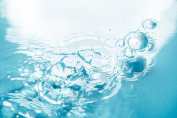 Naklejka na ściany i meble Defocus blurred blue color water ripple surface clear calm texture background with splashing bubbles water drop. Abstract and nature concept. Shiny water wave sunlight reflection shining copy space.