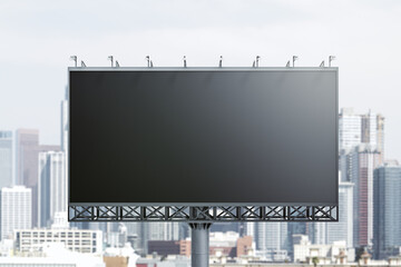 Blank black billboard on city buildings background, front view. Mockup, advertising concept