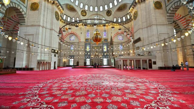 Interior view of the Suleymaniye mosque in Istanbul, Turkey. A lot of illumination, painted ceiling, red carpet