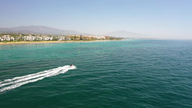 Aerial view of people with a jet ski along the coast off Estepona town, Malaga, Spain.