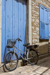 Fototapeta na wymiar Bicycle Lying Against Blue Door in Greece