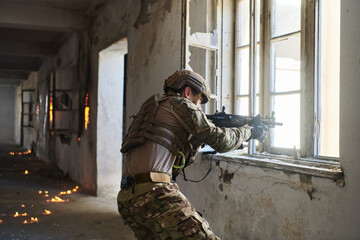 Fototapeta premium A professional soldier carries out a dangerous military mission in an abandoned building