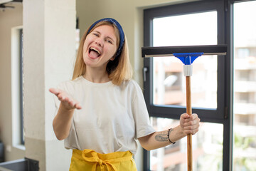 young pretty woman smiling happily and offering or showing a concept. windows washer concept