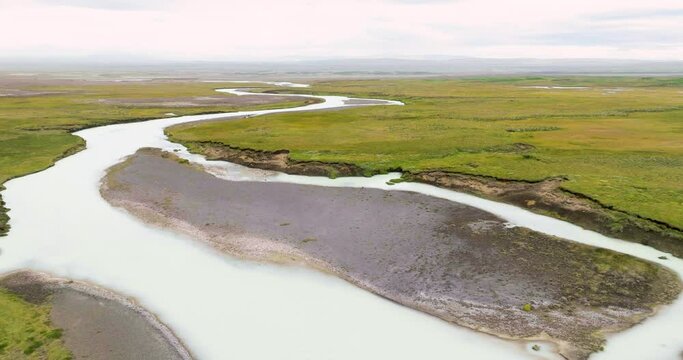 Aerial view of winding river Sanda with sandbanks and receding river banks in the desolate highlands of Iceland.