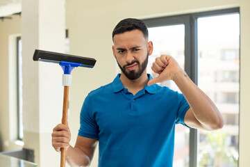 young  adult man feeling cross,showing thumbs down. windows washer concept