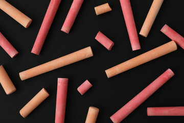 Multicolored pieces of chalk on a black background