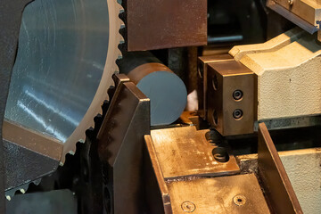 Close up scene the operation of circular blade saw cutting machine cutting the metal shaft parts with coolant method.