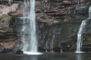 Waterfall, jets of water flowing down a rocky wall. Faido, Swiss.