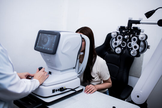 Woman optical shop customer doing eyesight measurement with optical phoropter check eye distance for eyeglasses is optical  eye shop service