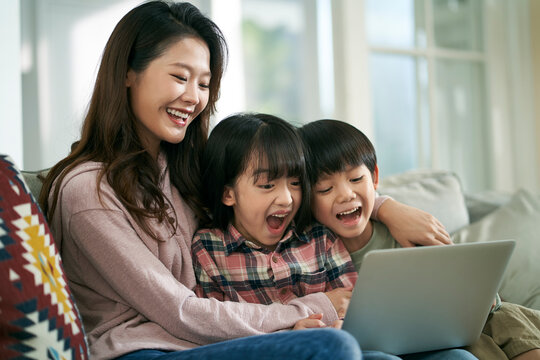 young asian mother and two children using laptop computer together