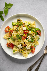 Pasta salad. Traditional Italian pasta with cherry tomatoes, olives, feta cheese, green lettuce