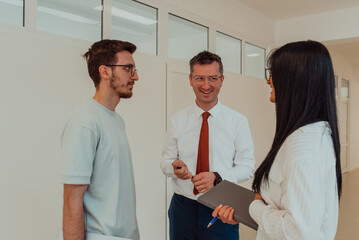 The director conducts a conversation with the secretary and a young programmer in a modern and...