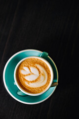 Coffee cappuccino in cup on wooden table in cafe