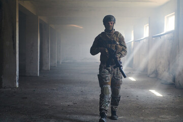 A professional soldier in an abandoned building shows courage and determination in a war campaign