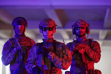 Soldier squad team walking in urban environment colored lightis