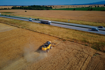 Harvesting machine working at agricultural field. Combine harvester collecting golden wheat field....