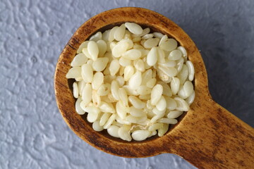 close up of sesame flour and sesame seeds in a wooden spoon. alternative type of flour. gluten free product. flour for dieting and low carb healthy meal