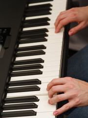 Obraz premium MIDI keyboard close up. Musician's hands on the keys. Musician, composer, sound recorder, composer. Modern musical instrument.