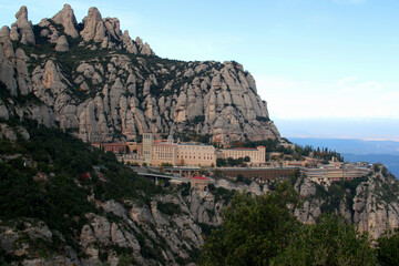 Photo of the Montserrat monastery against the background of the mountains against a gradient blue sky in the National park near Barcelona, Catalonia, Spain