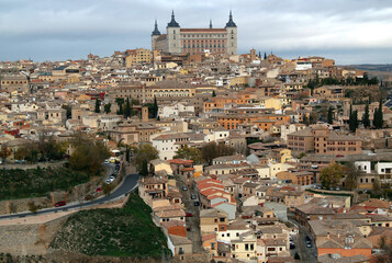 Fototapeta na wymiar Panoramic view of the historic part of the city with the Alcazar de Toledo military museum building on the hill against a stormy sky in the city of Toledo, near Madrid, Spain