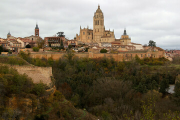 Fototapeta na wymiar Panoramic view of the historic part of the city with the Cathedral in the center of the photo against a stormy sky in the city of Segovia, near Madrid, Spain