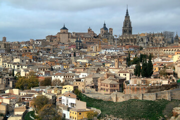 Fototapeta na wymiar Panoramic view of the historic part of the city with the Cathedral of Toledo in the center of the photo against a stormy sky in the city of Toledo, near Madrid, Spain