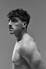 Fototapeta premium Portrait of young handsome man posing shirtless with serious facial expression. Muscular body. Black and white aesthetics. Concept of man's beauty, sportive and healthy lifestyle, athletic body