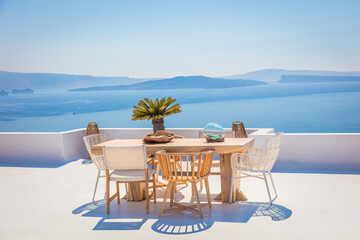 Santorini for rest. Greece, Santorini island, Oia - white architecture and deep blue. Table and chairs on the terrace. Greek Islands, Santorini