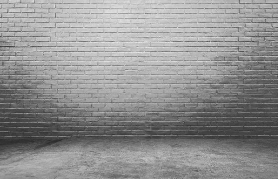 Fototapeta light grey brick wall background, rough concrete and plastered concrete floor, with glowing lights from above. lighting effect on empty brick wall background for design or product displayed.
