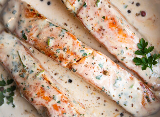 Cooked salmon fish with cream sauce in frying pan