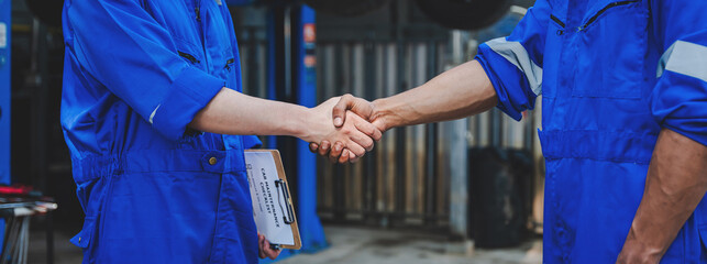 Auto mechanic handshake showing success collaboration of mechanics Check and maintain the engine for customers.