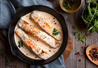 Fototapeta na wymiar Cooked salmon fish with cream sauce in frying pan