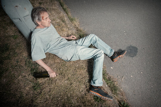 Addicted old man drunked in summer city park inable to walk