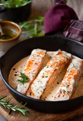 Cooked salmon fish with cream sauce in frying pan