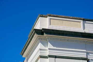 Wooden cornice at roof line of white commercial building © JohnBlottman