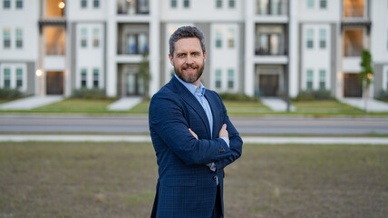 photo of smiling businessman in the suit outdoor at the house