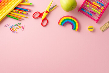Schoolroom supplies concept. Top-view of pop-it pencil case with pencils, clips, scissors, ruler, sharpener, abacus, fresh apple on pastel pink backdrop, allowing space for personalized message