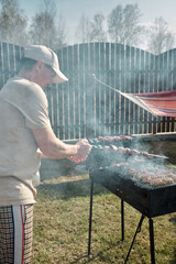 man grilling meat in the backyard of the house